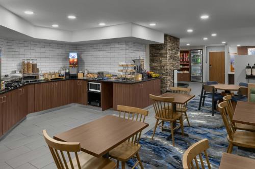 a restaurant with tables and chairs and a kitchen at Fairfield Inn Boise Airport in Boise