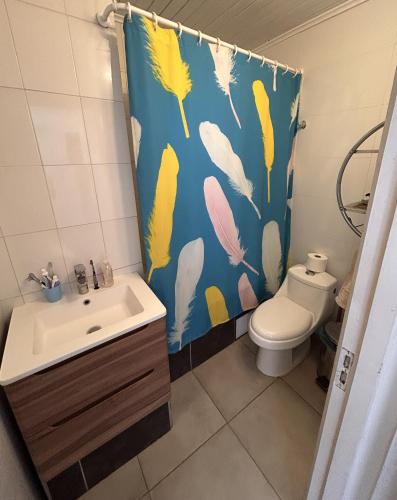 a bathroom with a toilet and a shower curtain at CasaMar Tongoy in Tongoy