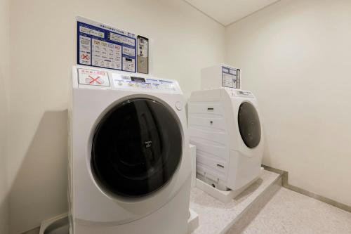 a bathroom with a washing machine and a sink at Four Points Flex by Sheraton Tokyo Shibuya West in Tokyo