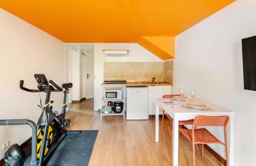 een keuken met een tafel en een fiets in een kamer bij Studio Wellness & Détente Cosy in Maubec