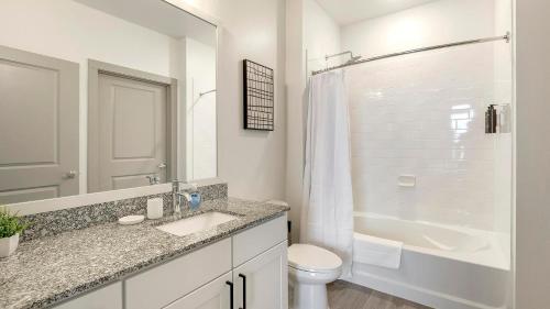 a bathroom with a sink and a toilet and a tub at Landing Apartments - Atlas Bluewood in Celina