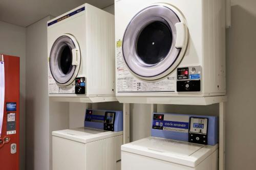 a laundry room with two washes and two machines at Four Points Flex by Sheraton Tokyo Ueno in Tokyo