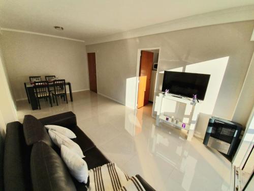 een woonkamer met een bank en een flatscreen-tv bij Departamento en Barrio La Perla, Mdp in Mar del Plata