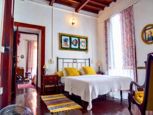 een slaapkamer met een bed met gele kussens bij Casa Verde de Guía in Santa Maria de Guia de Gran Canaria