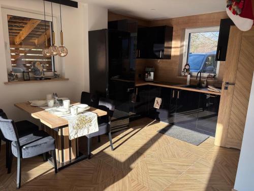 una cucina con tavolo e sedie e una sala da pranzo di Apartamenty Słowianka-Chatka pod lasem a Wolibórz