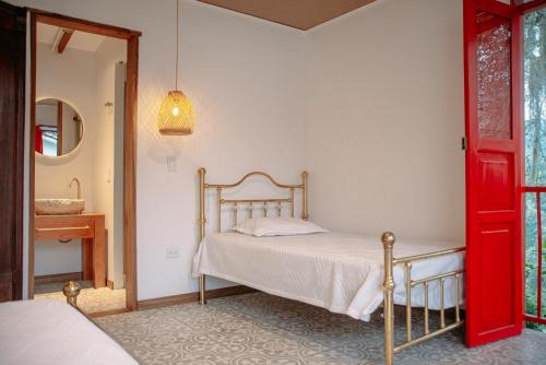 una camera da letto con un letto e una porta rossa di Hacienda Santa Bárbara Coffee Farm a La Linda