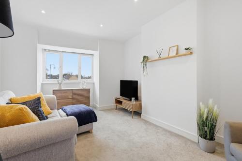 a living room with a couch and a tv at Central Apartment - 16 Mins to London in Potters Bar