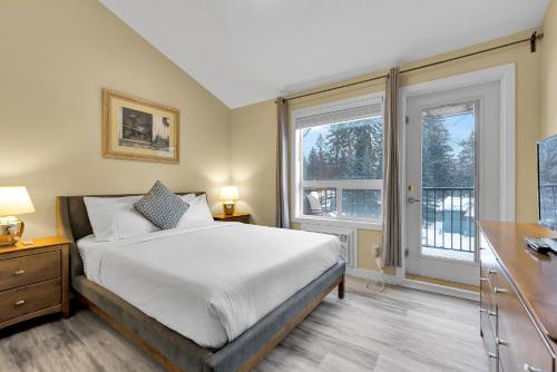 a bedroom with a bed and two windows at banff woods lodge in Canmore