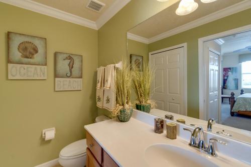 a bathroom with a sink and a toilet and a mirror at River Strand Country Club Condo with Pool Access! in Bradenton