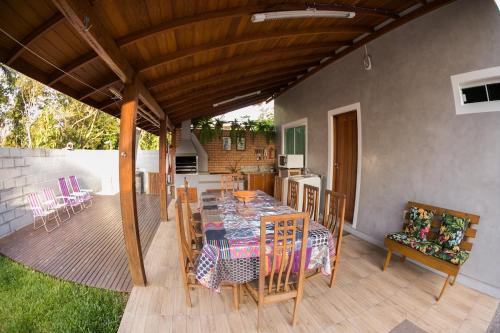a patio with a table and chairs on a deck at Casa Ampla na Guarda do Embau in Lages