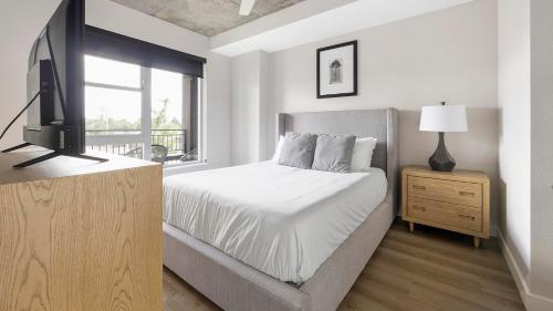 a bedroom with a bed and a tv and a window at Landing Modern Studio Rooftop Lounge Gym in Englewood