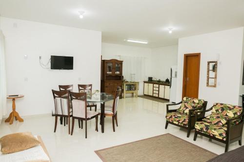 a living room with a glass table and chairs at Casa Ampla na Guarda do Embau in Lages