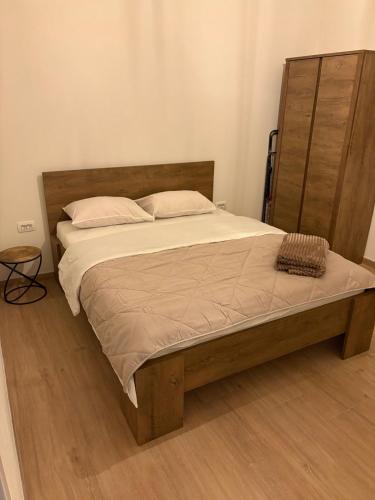a bedroom with a large bed with a wooden headboard at Holiday home Lavande in Tivat