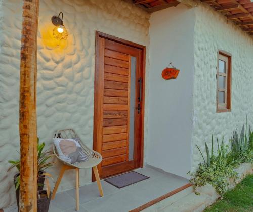 une porte d'une maison avec une chaise à côté dans l'établissement Wind Village Icaraizinho, à Icaraí