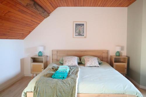 een slaapkamer met een bed met een houten plafond bij Gîtes Le Gros Chêne in Meaucé