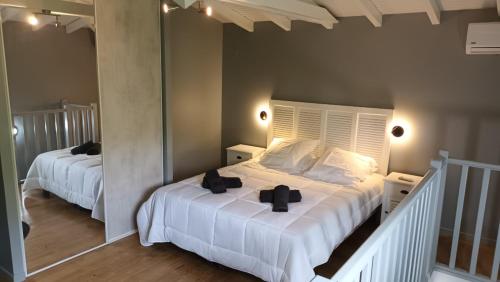 - une chambre avec 2 lits avec des arcs noirs dans l'établissement LE DOMAINE de L'HYLODE, à Sainte-Anne