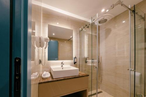 een badkamer met een wastafel en een douche bij Moenia Boutique Hotel in Durrës