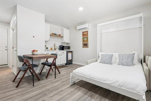een slaapkamer met een bed en een tafel en een keuken bij Cozy Studio Retreat with Private Bath & Kitchenette in Tempe