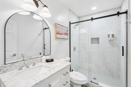 een witte badkamer met een wastafel en een douche bij Cozy Studio Retreat with Private Bath & Kitchenette in Tempe