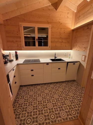 une cuisine dans une cabane en rondins avec un évier dans l'établissement Staubbachbänkli, à Wengen