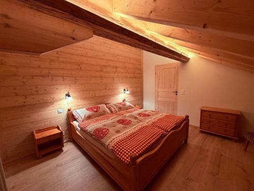 une chambre avec un lit dans une pièce aux murs en bois dans l'établissement Staubbachbänkli, à Wengen