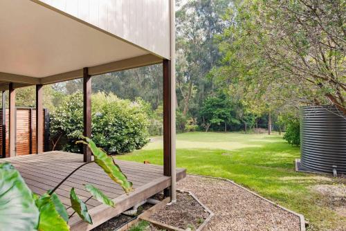 a wooden deck with a view of a yard at Yaringa at Bawley in Bawley Point