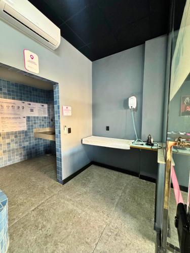 a bathroom with blue walls and a counter with a shelf at City Studios Apartamentos Novos em Natal in Natal