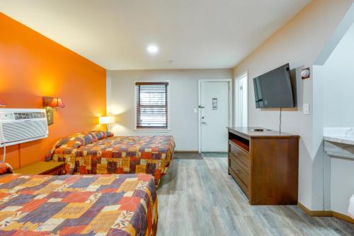 a hotel room with two beds and a flat screen tv at Ski, Explore, Bring Pets! Studio 5 Mi to Pine Knob in City in the Village of Clarkson