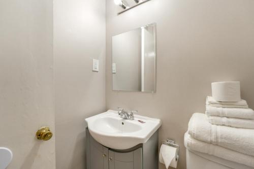 a bathroom with a sink and a mirror and towels at Ski, Explore, Bring Pets! Studio 5 Mi to Pine Knob in City in the Village of Clarkson