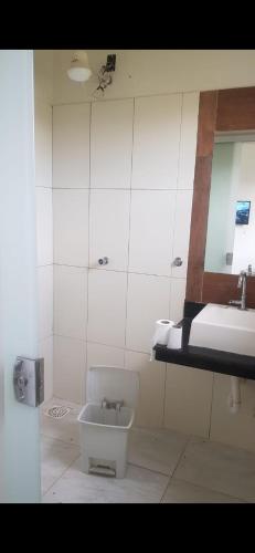 a white bathroom with a sink and a toilet at Sitiolosbragas in Caetanópolis