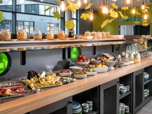 ein Buffet mit vielen verschiedenen Speisen in der Unterkunft ibis Styles Stuttgart Vaihingen in Stuttgart