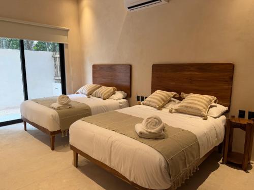 una camera da letto con due letti con asciugamani sopra di Balam Tulum a Cedro
