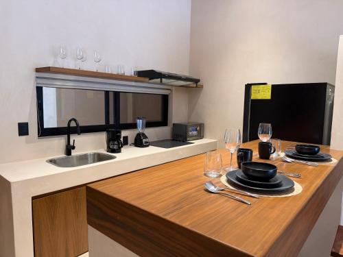 una cucina con lavandino e bancone con bicchieri da vino di Balam Tulum a Cedro