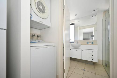 a white bathroom with a sink and a mirror at Ocean Views Retreat, Caloundra in Caloundra
