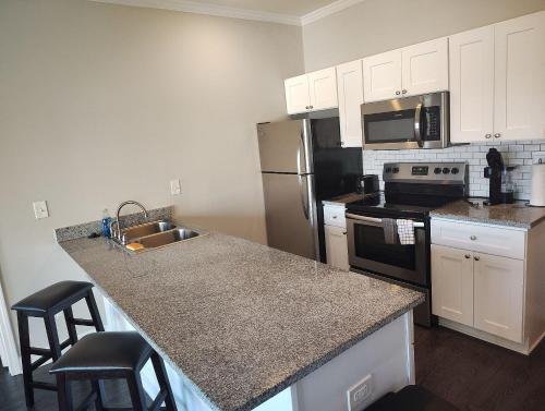 a kitchen with a stainless steel refrigerator and a sink at Relax and Explore Poolside Stay Near Local Spots in Sunny Acres