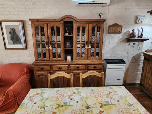 a kitchen with a wooden china cabinet and a table at Lo de Capra! in Santa Clara del Mar