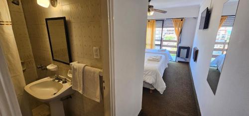 un bagno con un lavandino e un letto in una stanza di Hotel Soleares a Mar del Plata