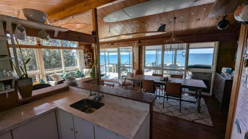 a kitchen and dining room with a view of the ocean at Gorgeous Beach House in Pukehina