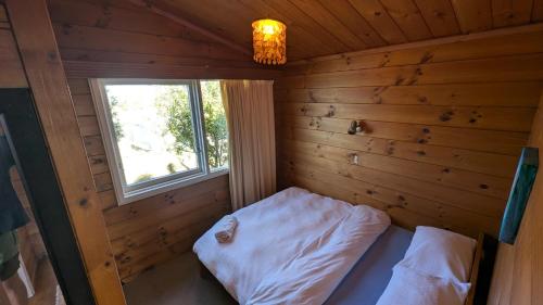 a small room with a bed and a window at Gorgeous Beach House in Pukehina