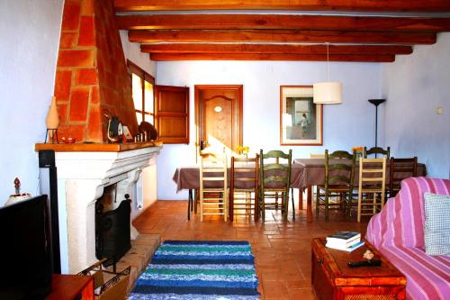sala de estar con chimenea, mesa y sillas en Mas Saris, en Peratallada