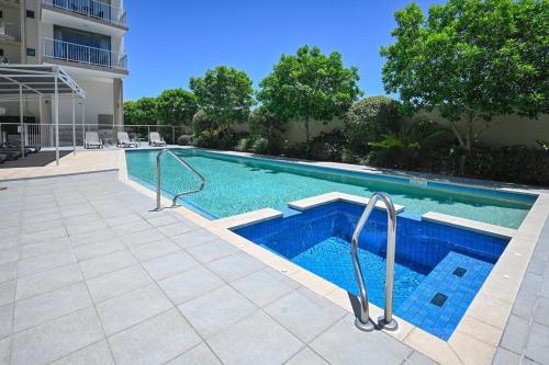 a swimming pool with blue water in a building at Bulcock Street Beachside Haven in Caloundra