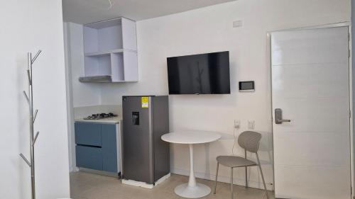 a small kitchen with a small table and a refrigerator at Loft 201 H54 Waiwa host in Bucaramanga