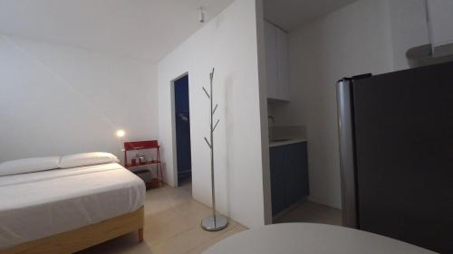 a bedroom with a bed and a refrigerator in it at Loft 201 H54 Waiwa host in Bucaramanga