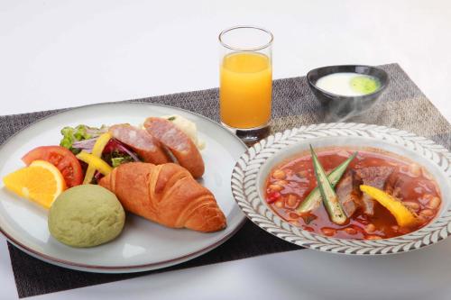 un tavolo con un piatto di cibo e una ciotola di zuppa di Hotel Sunflex Kagoshima a Kagoshima