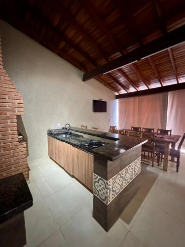 a kitchen with a sink and a table with chairs at Casa Completa Para Dias Perfeitos in Olímpia