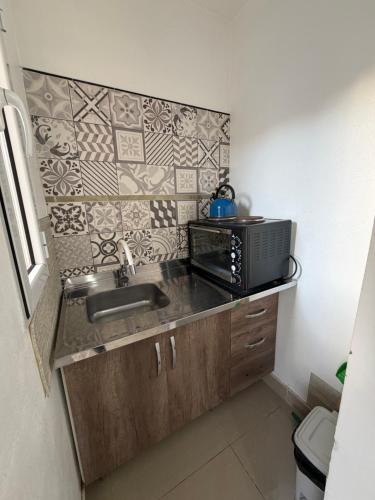 eine Küche mit Spüle und Mikrowelle in der Unterkunft SAN FRANCISCO in Comodoro Rivadavia