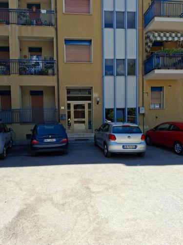 due auto parcheggiate in un parcheggio di fronte a un edificio di L'attico di Ovidio a Sulmona