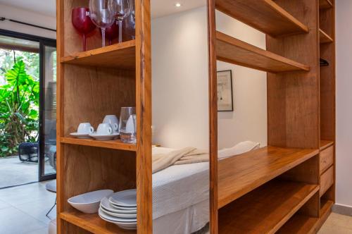 een kamer met houten planken vol borden en kommen bij Flat Pitanga in Camburi