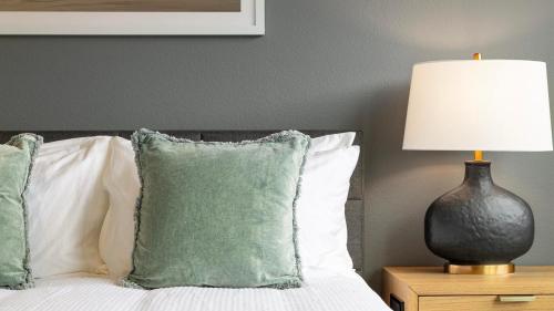 una camera da letto con un letto con una lampada e cuscini di Landing Chic 2BD Gym Pool a Frederick