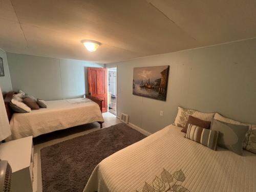 a bedroom with two beds and a painting on the wall at Sunset Cottage in Havana